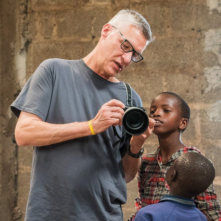 Thom showing African kids his camera at a mission trip