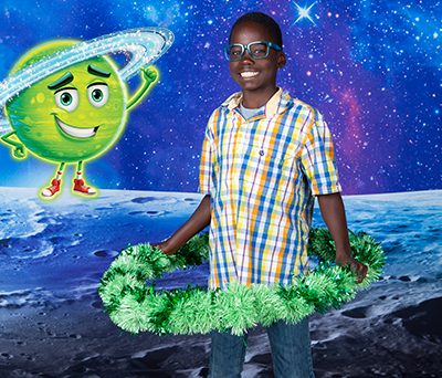 Boy holding a green hula-hoop with Ringo the Bible Memory Buddy