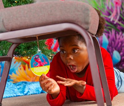 boy excited about finding an ornement under his chair