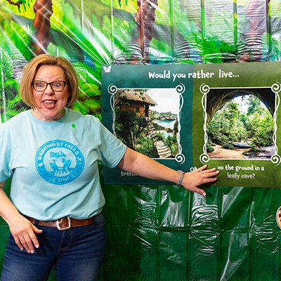 VBS Leader pointing to a poster with the jungle on it