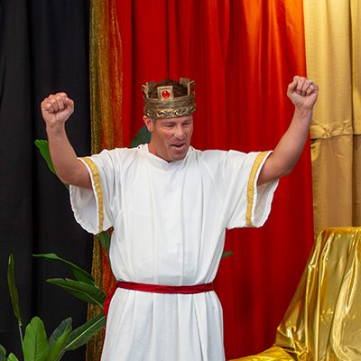 VBS volunteer dressed like King David wearing a crown